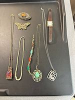 All jewelry items laid on black tray showing overall lot
