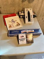 Group view of all items: square plate, frother set, playing cards, wooden card holder box