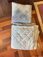 Blanket folded and pillow showing diamond quilting and color