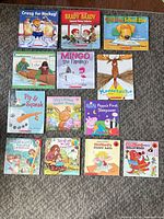 Thirteen children’s board and picture books arranged on floor showing full covers