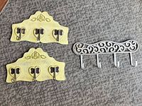 Group shot of two yellow wood plaques and one silver metal rack on carpet