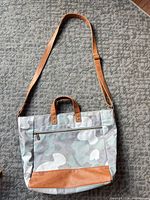 Full view of camo tote with shoulder strap attached