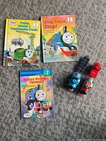 Group view of three books and two plastic engines on carpet