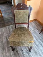 Full view of chair showing wood frame, upholstery and casters