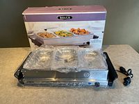 Buffet server in front of retail box, trays and lids wrapped in plastic