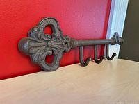 Front view of cast iron key holder showing overall design and four hooks