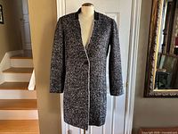 Front view of black and white bouclé coat on mannequin