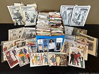 Full lot view showing box filled with numerous pattern envelopes and several displayed around it