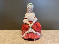 Frontal view of figurine showing dress, pose, paint condition