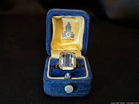 Ring in open blue velvet box interior logo visible