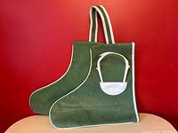 Front view showing boot shape, striped handles, white piping, and attached mini pouch