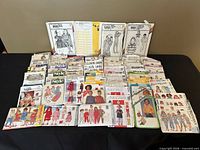 lot overview of approx. 70 children’s sewing patterns displayed on table
