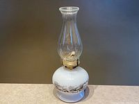 Full view of oil lamp showing base scene, burner and chimney