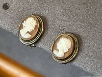 Front view of both cameo earrings showing carved profiles and rope borders