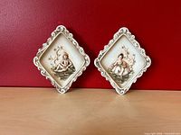 Both plaques front view against red wall