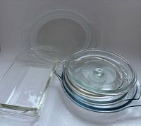 Group shot showing all five Pyrex lids stacked and Fire-King baker beside them