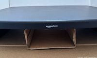 Front view of assembled AmazonBasics monitor stand on top of boxes