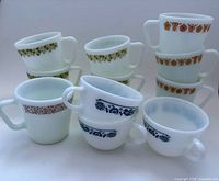 Front view showing all 11 Pyrex milk glass pieces grouped by pattern