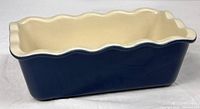 Side profile showing navy blue exterior and cream interior of loaf pan