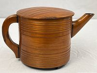 Side view showing full teapot profile, handle, spout, ribbed body