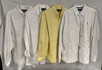 Four shirts hanging side by side showing overall lot