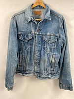 Front view of Levi's denim jacket hanging, showing overall style and pockets