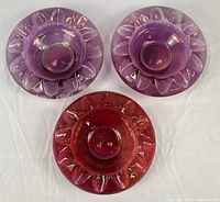 Top view of three glass ashtrays displaying colors and scalloped pattern