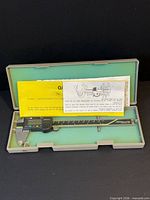 Caliper in open case with paperwork visible