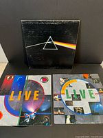 Front covers of all three LP sleeves showing prism cover and two LIVE inner sleeves