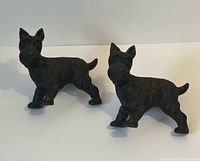 Front view of both cast iron Scotty dog doorstops