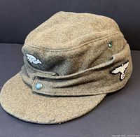 Front and side view of grey wool M43 cap with insignia and buttons visible