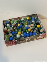 Open floral box filled with assorted glass marbles