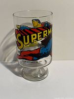 Front view showing SUPERMAN logo and hero graphic on glass