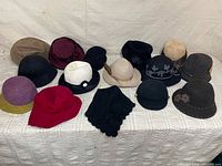Group shot of all fifteen assorted women’s hats displayed on surface