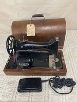 Full view of Singer sewing machine in wooden case with foot pedal