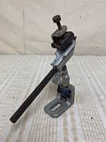 Full view of drill grinding attachment showing base, arm, guide rod and clamp