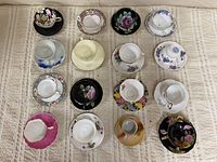Top-down view of 15 assorted teacup and saucer sets arranged in grid