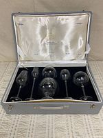 Open presentation case displaying six crystal snifters in fitted velvet base