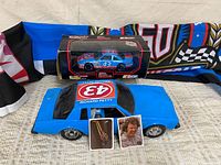 Lot overview showing large plastic car, boxed die-cast, flag and two cards