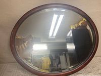 Front view of oval oak mirror showing frame and glass