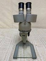 Front three-quarter view showing binocular head, stand and glass stage