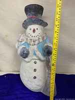 Full view of snowman with tape measure indicating height
