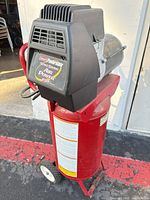 Full view of red vertical compressor with black motor housing and wheels