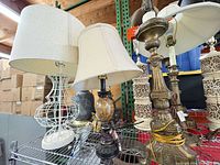 Multiple lamp bases and shades on shelf, showing primary items