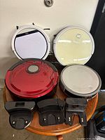 Four robot vacuums with three docks on table