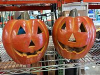 Front view of both ceramic pumpkins on shelf