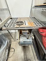 Overall view of Rockwell table saw showing table surface, motor and frame