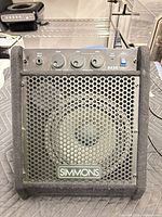 Front view of Simmons DA25 amp showing grille, speaker, controls
