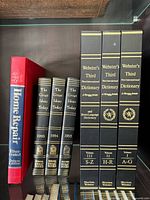 All seven hardcover books on shelf showing spines