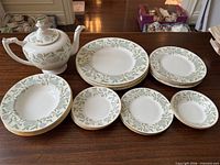Group shot showing full 21-piece set with teapot, plates and bowls
